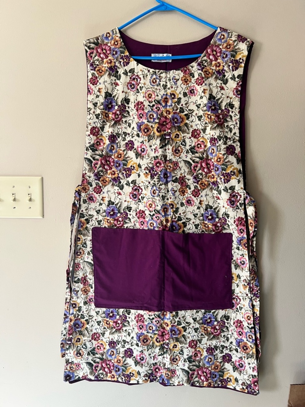 Hand made floral pattern smoke apron with open sides and ties. Purple lining.